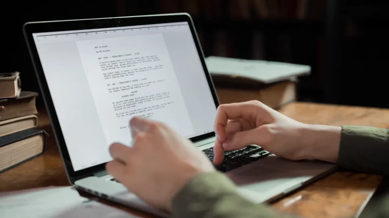 Hands reviewing a document on a laptop