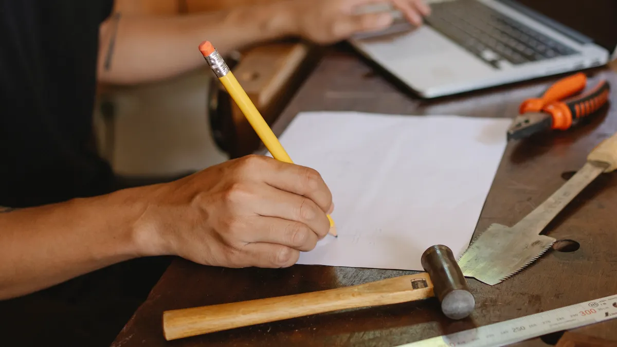 How to use a professional AI writer to produce compliant legal-first drafts — Crop artisan writing on paper and typing o